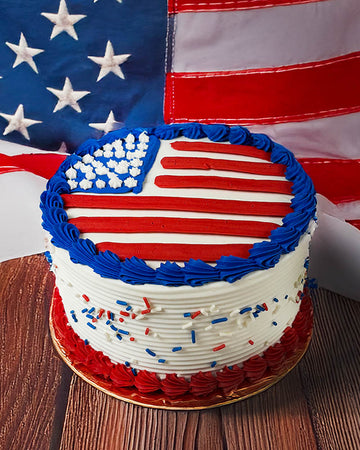 Cake decorated with an American flag design in front of an American flag